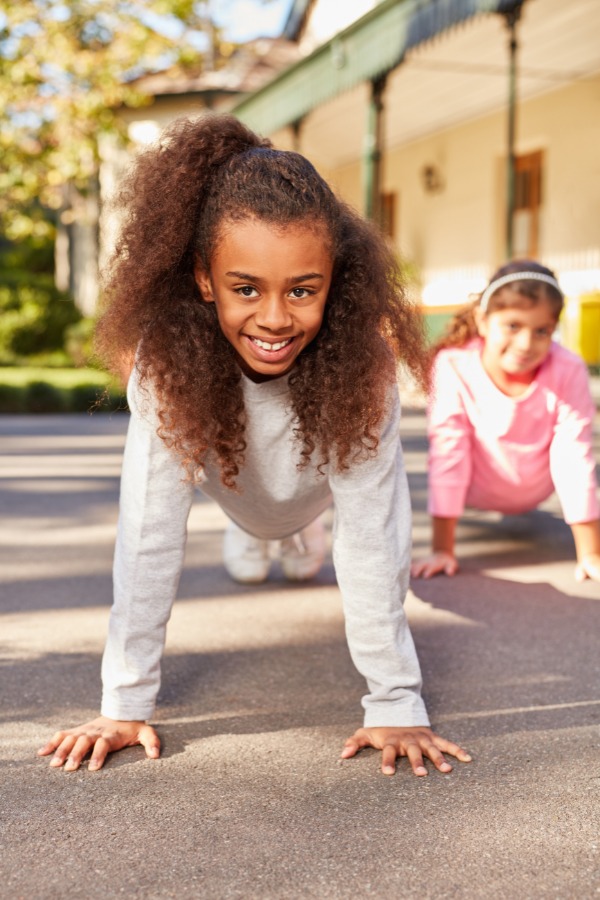 This photo shows two girls participating in a Simon Says game.