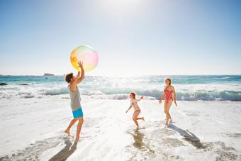 Family playing with ball by the ocean