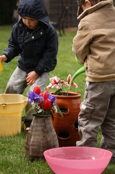 kids watering artificial flowers