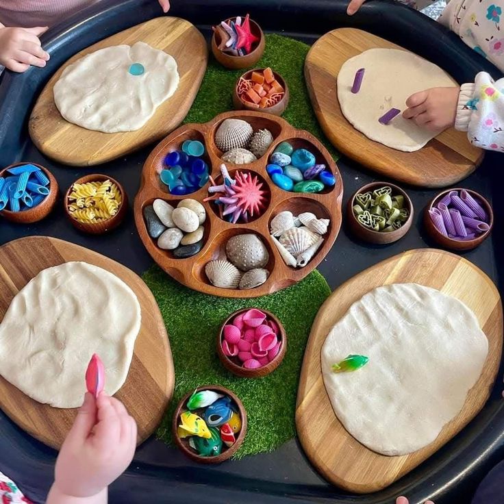 This may contain: children playing with play dough in a tray