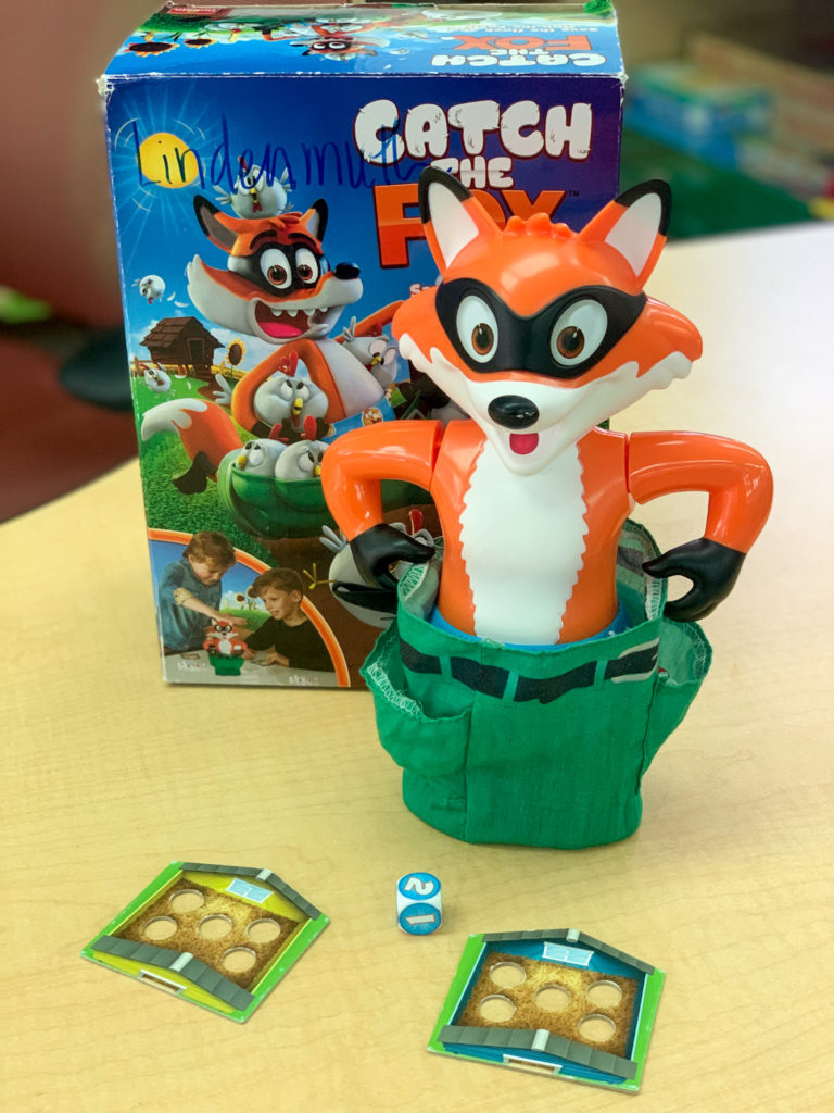 This is a photo of the game Catch the Fox.  The fox has chickens in his pants. 